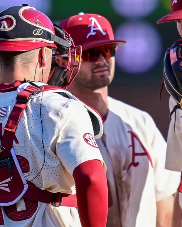Razorbacks pitching coach Matt Hobbs on mound with infield against UCA